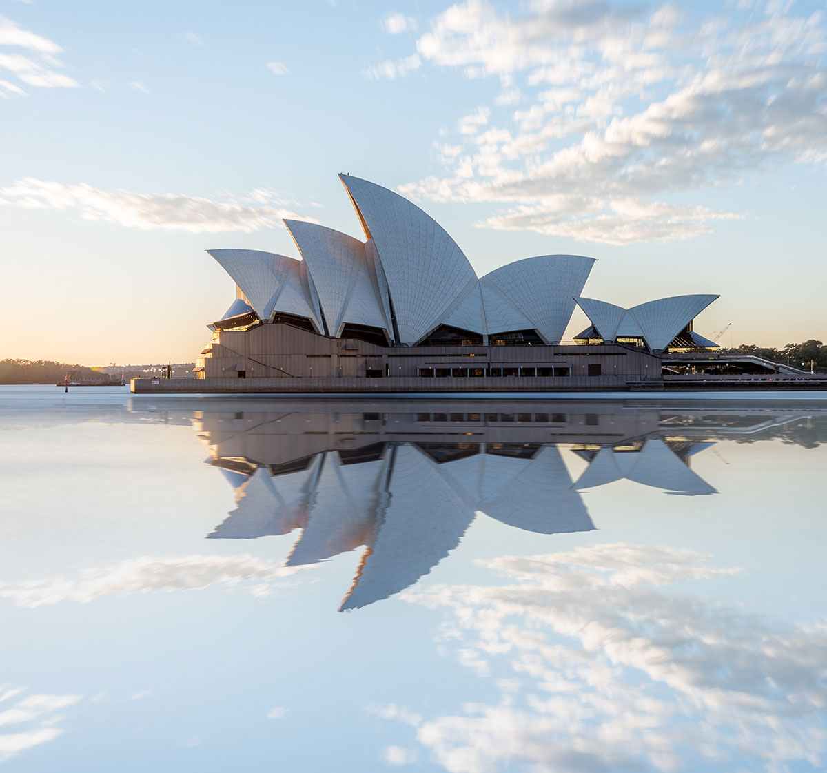 The Sydney Opera House reflecting in the still water of the harbor.