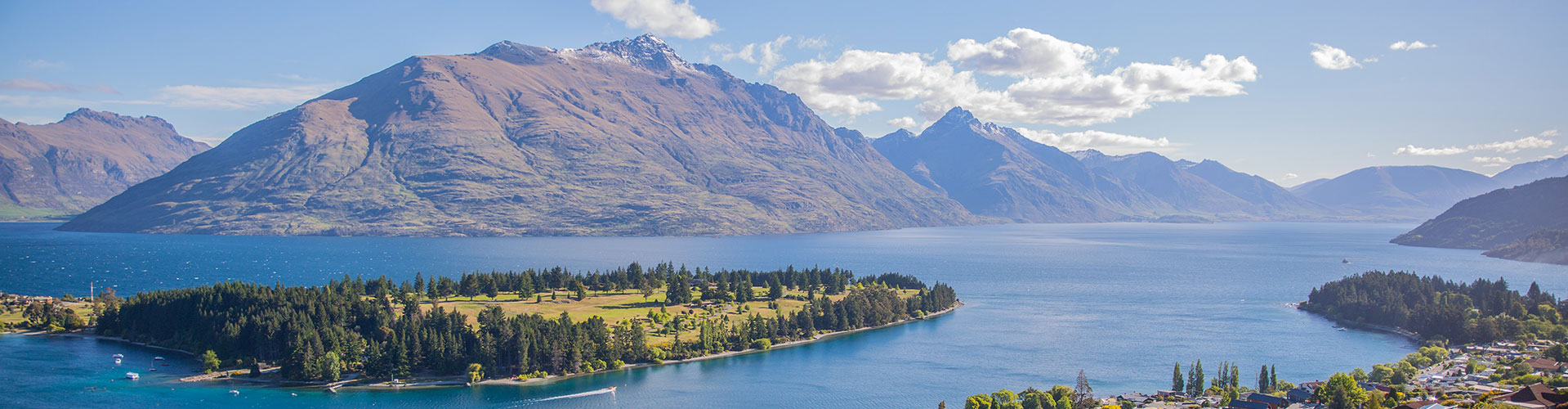 A beautiful lake with an island below snowcapped mountains in New Zealand.