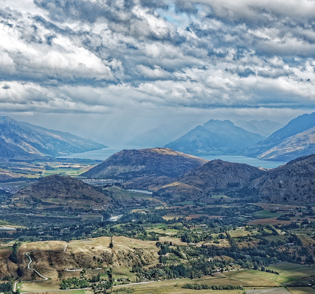 A farming valley in New Zealand with rolling hills and winding river.
