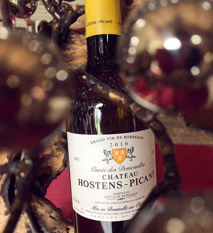 A bottle of Chateau Hostens-Picant's top white wine, the Cuvee des Demoiselles from Bordeaux, France.