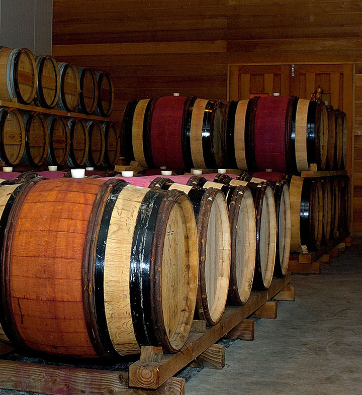 Oak barrels filled with organic wine aging in the cellar at FROMM winery in Marlborough, New Zealand.